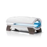 A white and brown tanning bed with blue lights.