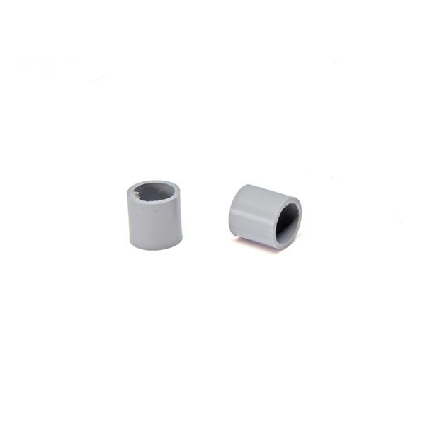 A pair of gray plastic spacers sitting on top of a white table.